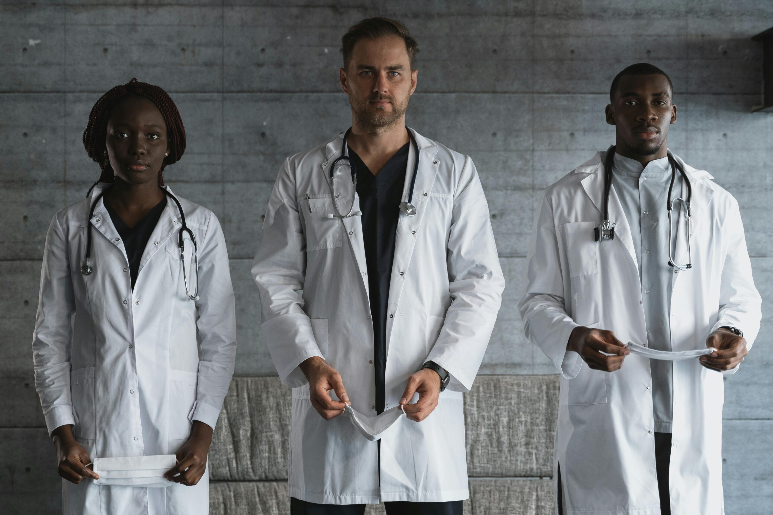 A diverse team of doctors in medical uniforms with stethoscopes in a hospital setting.