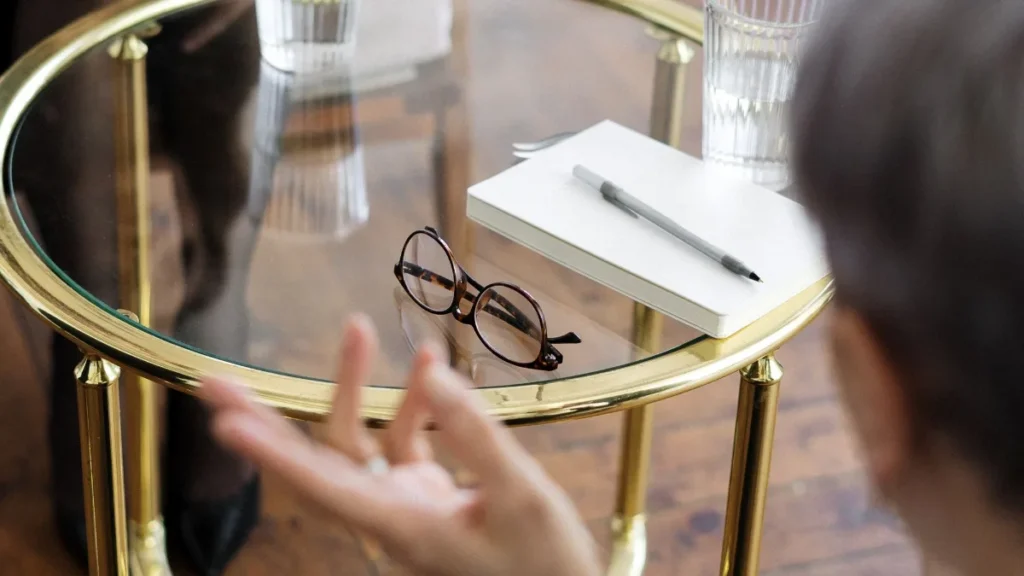 Addiction counselor meeting with a client at a table, placed by a drug and alcohol counselor staffing agency