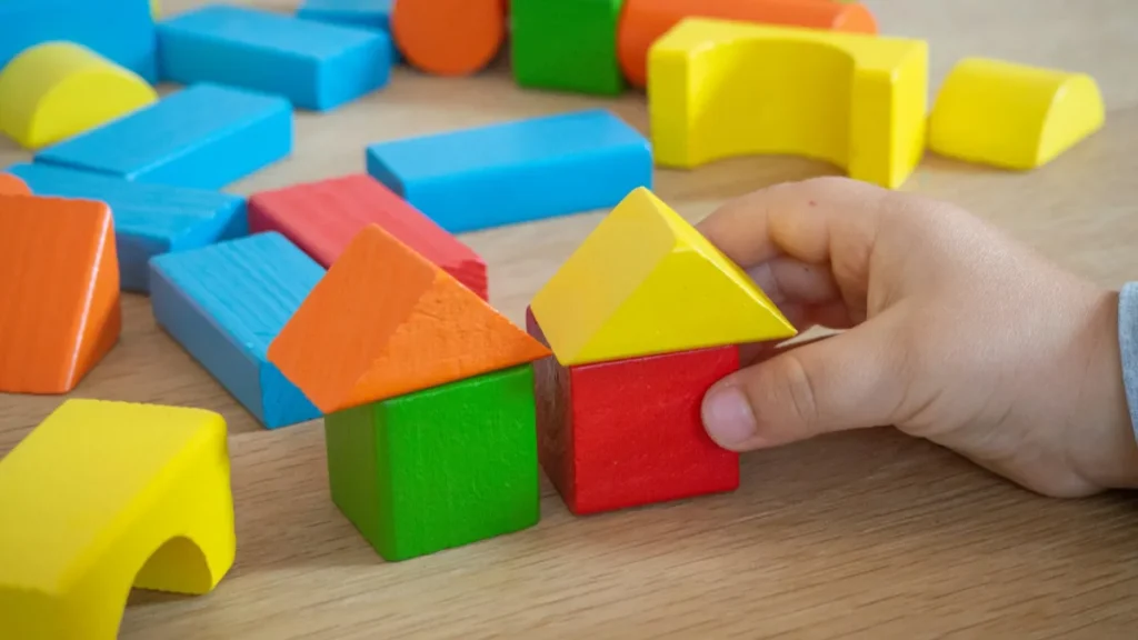 Child stacking colorful wooden blocks during an ABA session led by an RBT from an RBT staffing agency