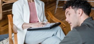 Psychiatrist listening to a patient during a consultation in a modern office, illustrating locum tenens psychiatrist coverage