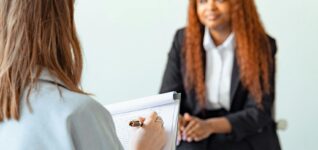 A female counselor conducts a therapy session with a client in a modern office setting.