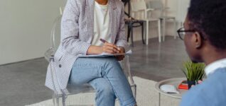 Professional therapist discussing with a client in a modern office setting.