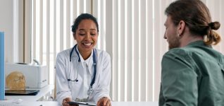 A doctor and patient engaging in a positive consultation in a bright clinic setting.
