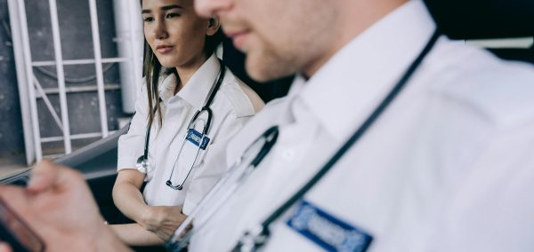 Focused emergency medical technicians discussing a case inside an ambulance.